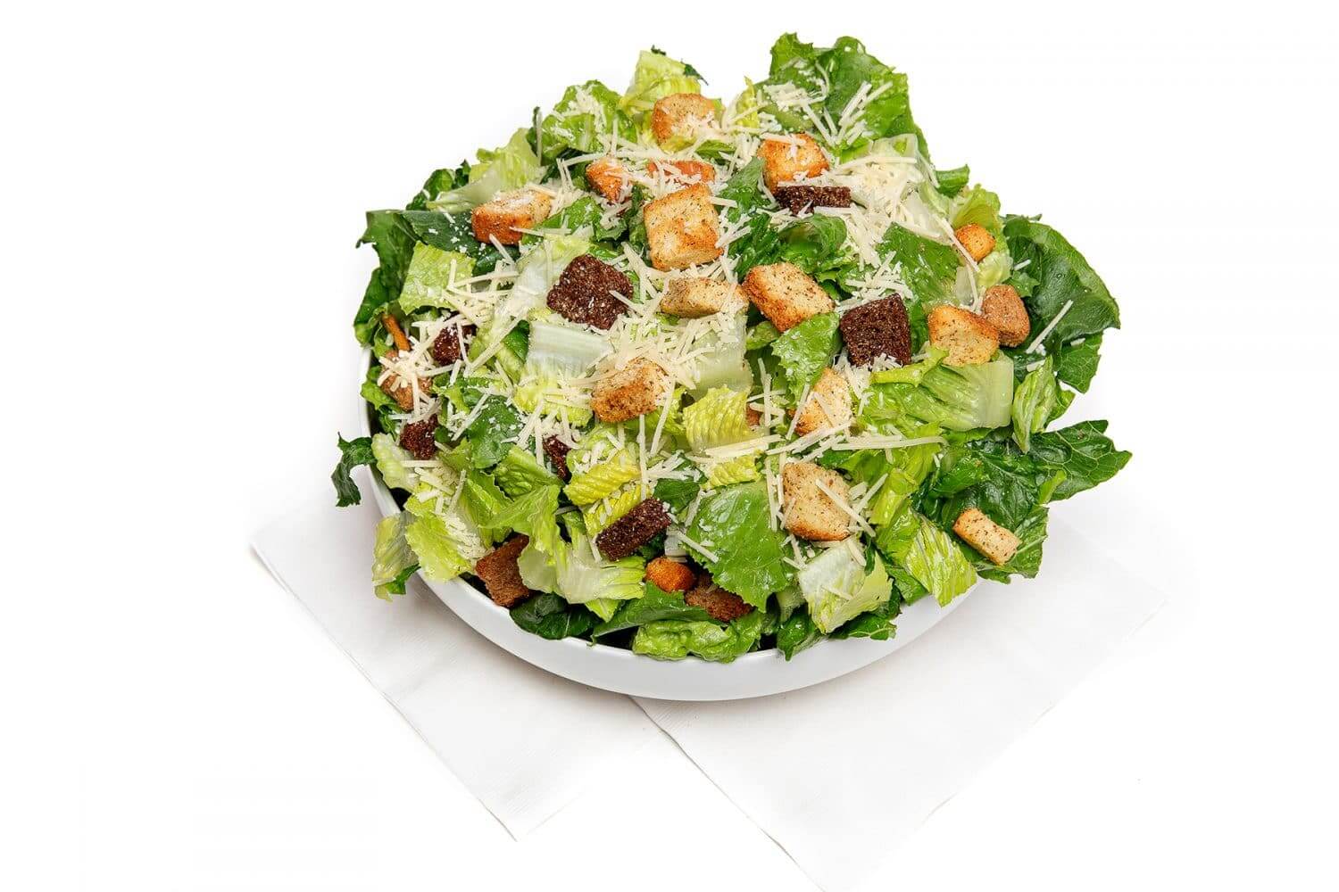 a bowl full of cesar salad with croutons
